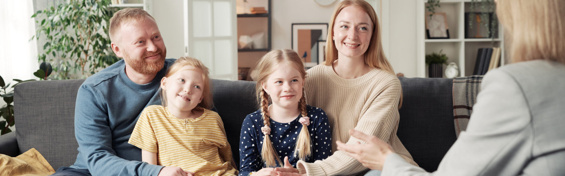 Smiling Family Talking on Couch in Bright Living Room